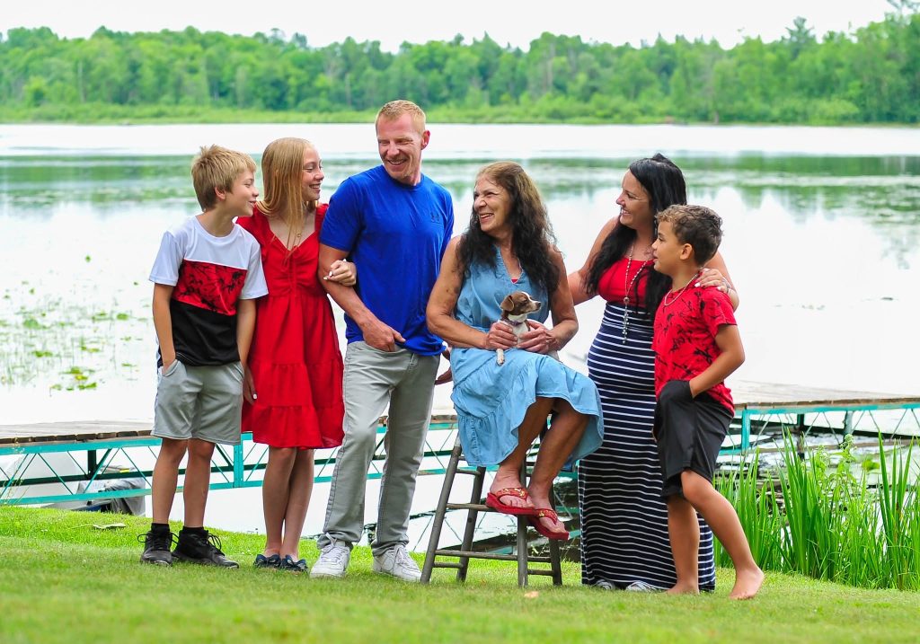 Family of six standing by a lake in summer