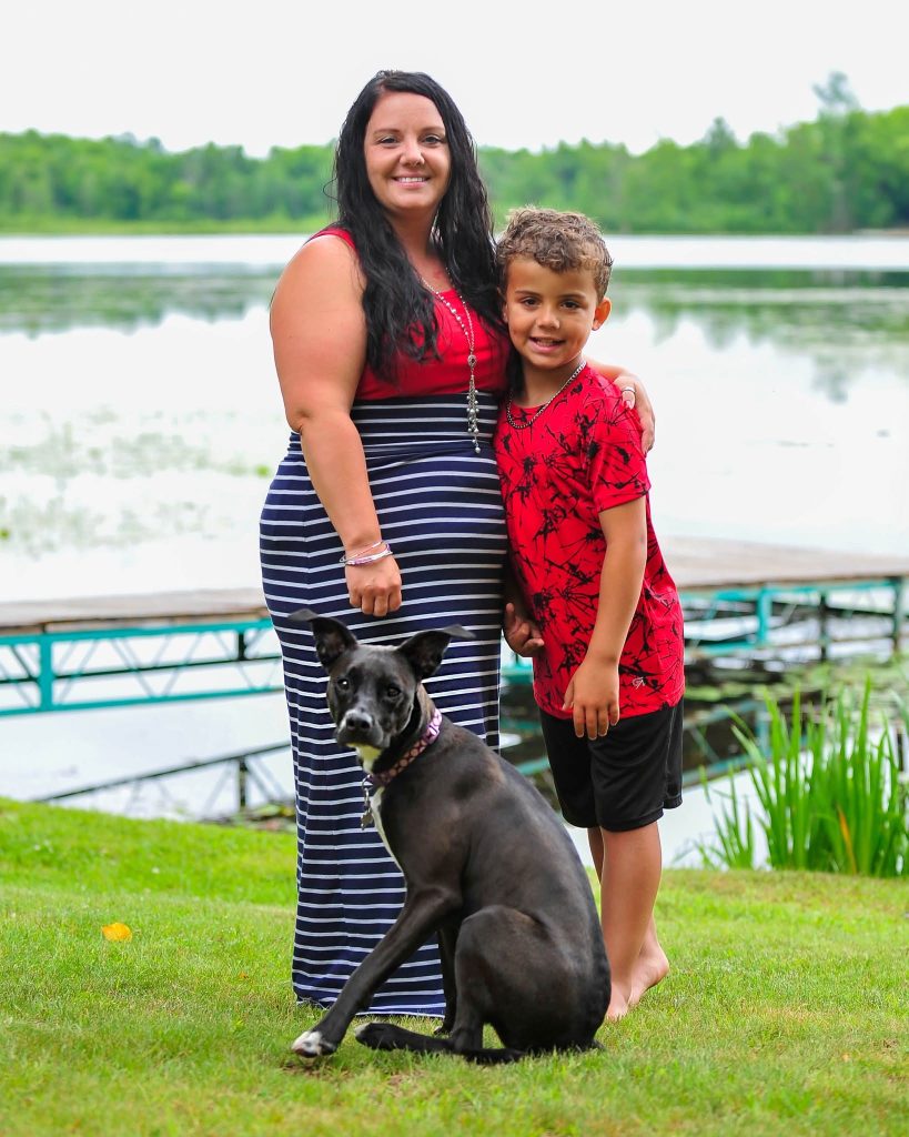 Mother and son with the family dog by the lake