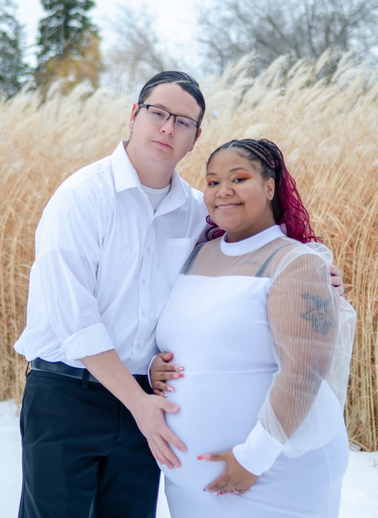 Maternity portrait of a couple in a snowy field