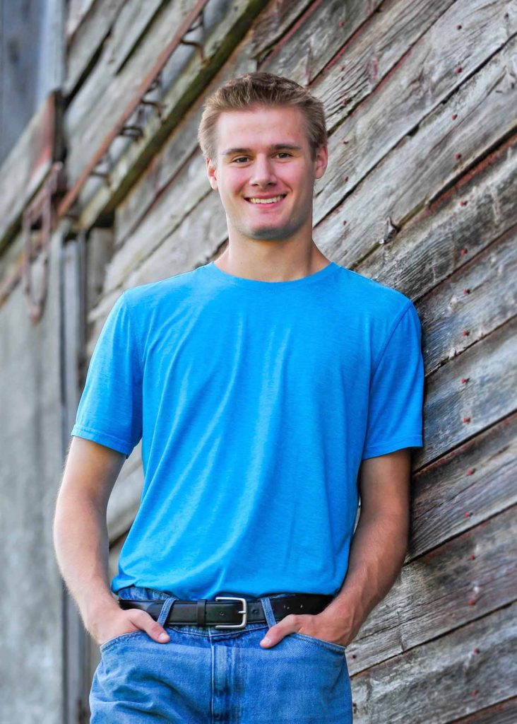 Senior portrait against weathered barn boards