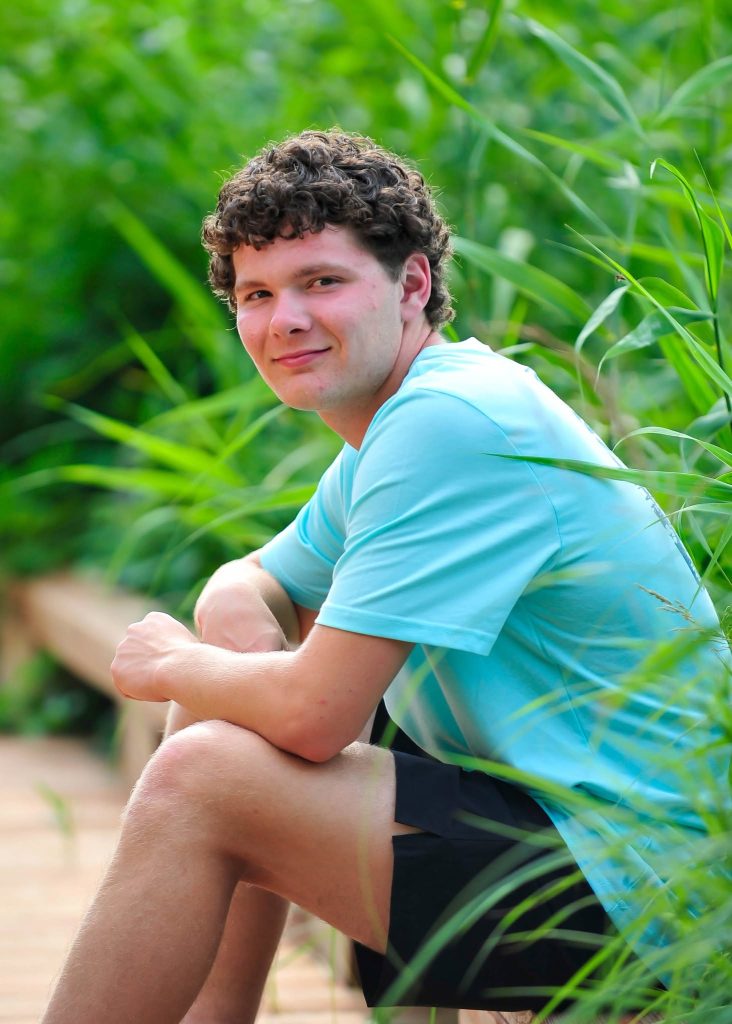 Senior seated on a boardwalk in tall reeds
